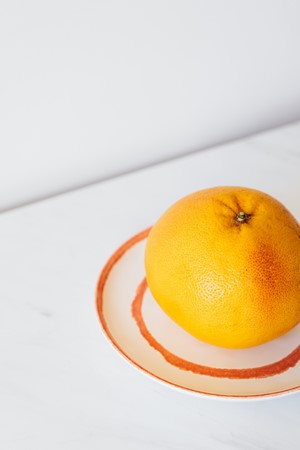 Grapefruit on plate on white table picture